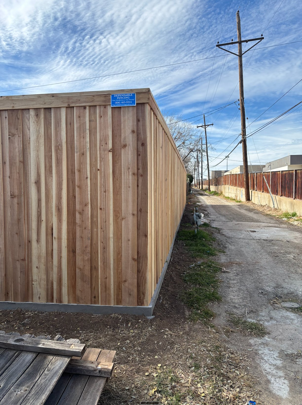 Dependable Fencing cedar privacy fence with company sign in Amarillo, TX